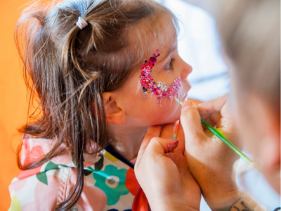 Photo of a young person getting their face painted