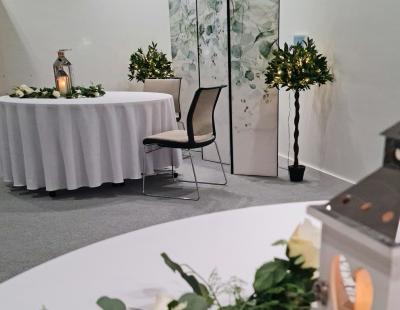 Interior photo of the ceremony room at 1 Time Square Warrington. Photo shows the front of the room set up for a wedding with flowers and candle decorations on tables. 